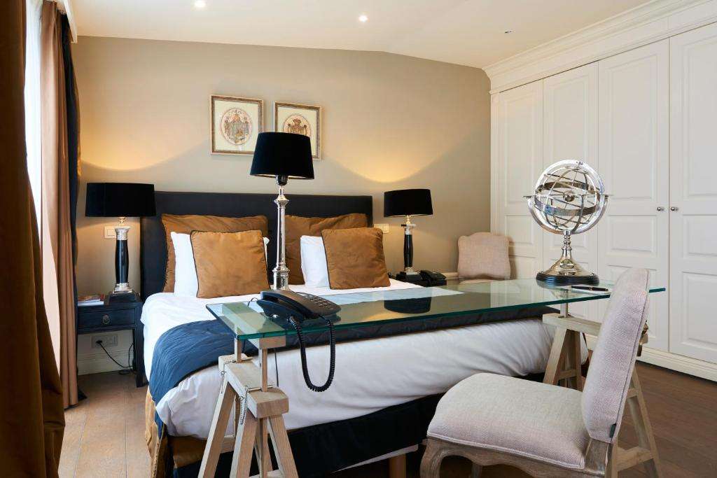 een slaapkamer met een bed met een bureau en een bureau bij Stanhope Hotel by Thon Hotels in Brussel