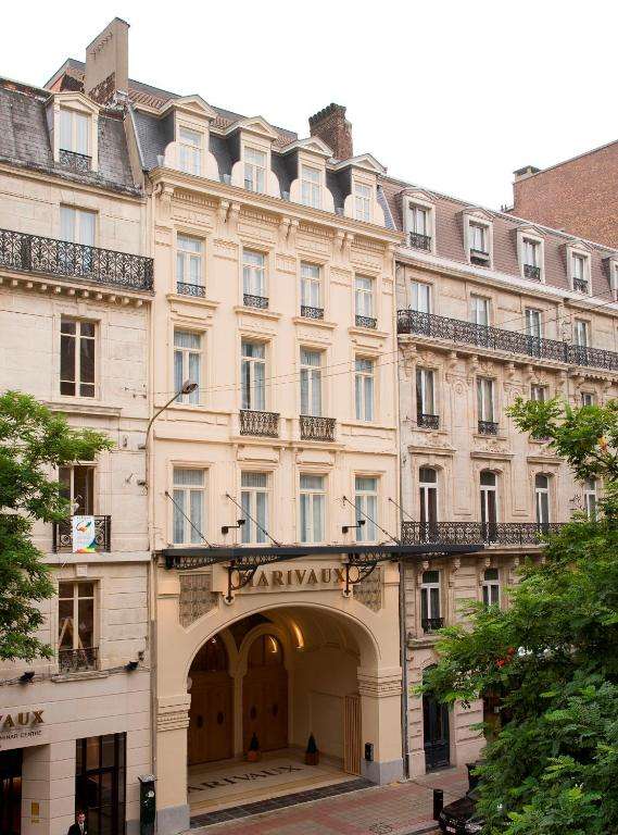 een groot gebouw met een boog ervoor bij Marivaux Hotel in Brussel