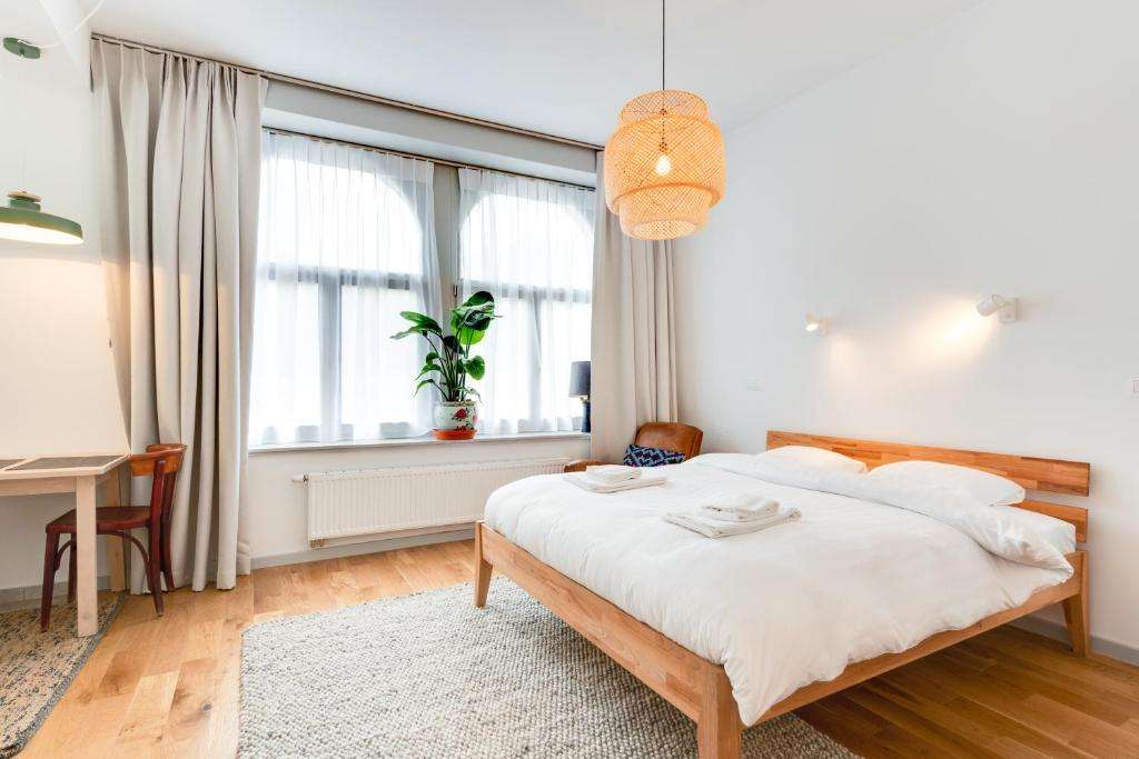 een slaapkamer met een bed, een bureau en een raam bij Newton Boutique Hotel Residences - Brussels EU Area in Brussel
