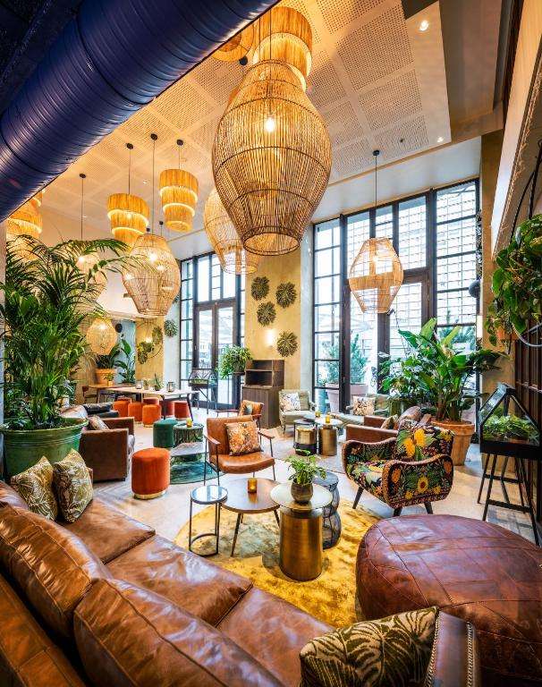 een lobby met een leren bank en tafels en stoelen bij Hotel Indigo Brussels - City by IHG in Brussel