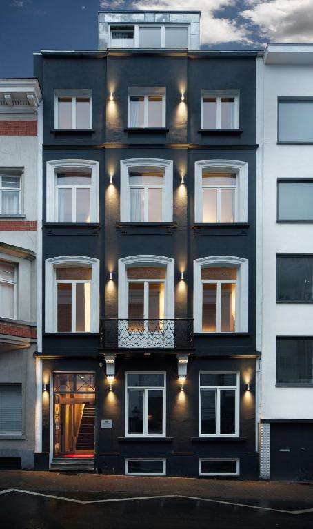 een zwart-wit gebouw met een balkon bij Hotel The Neufchatel in Brussel