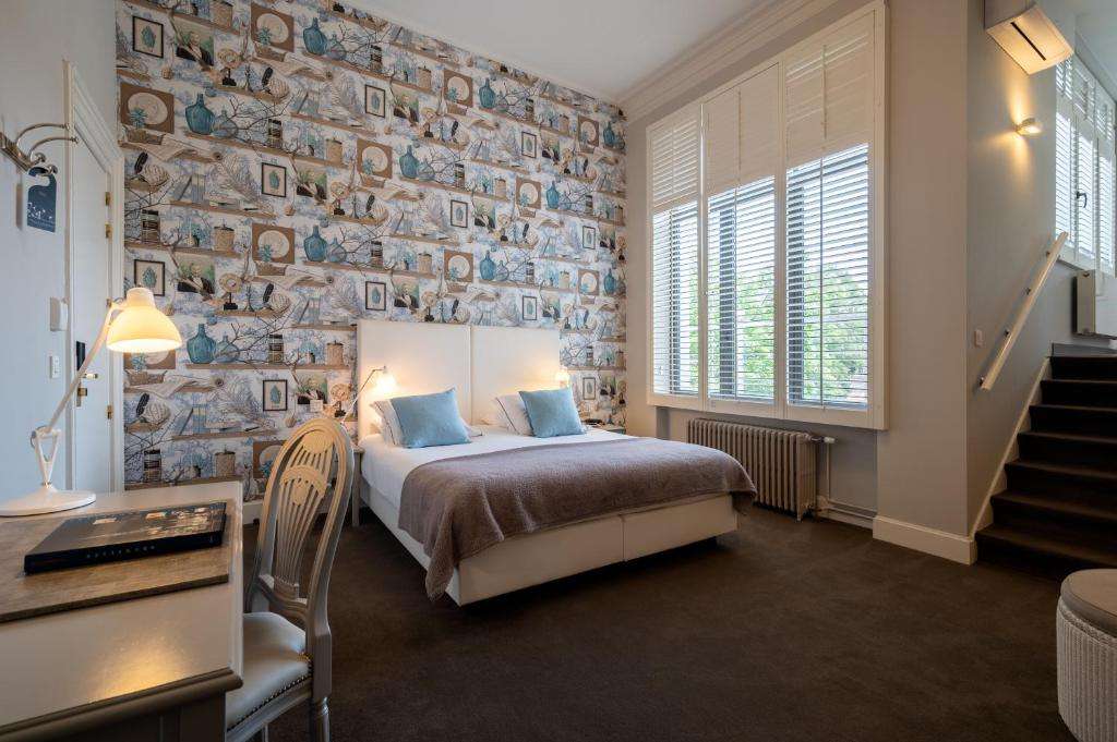 een slaapkamer met een bed en een stenen muur bij Hotel Made In Louise in Brussel