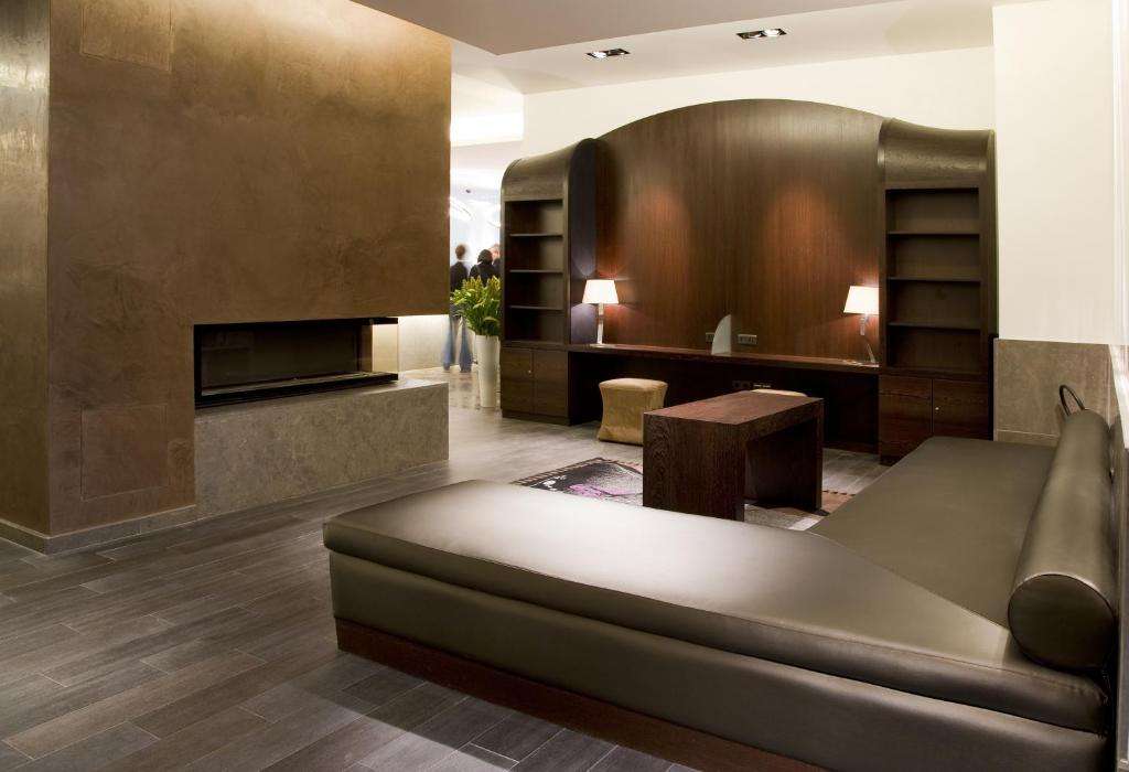 een woonkamer met een bank en een open haard bij Marivaux Hotel in Brussel