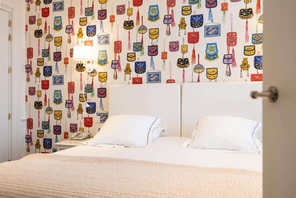 een slaapkamer met een bed met een muur bedekt met stickers bij Hotel Made In Louise in Brussel