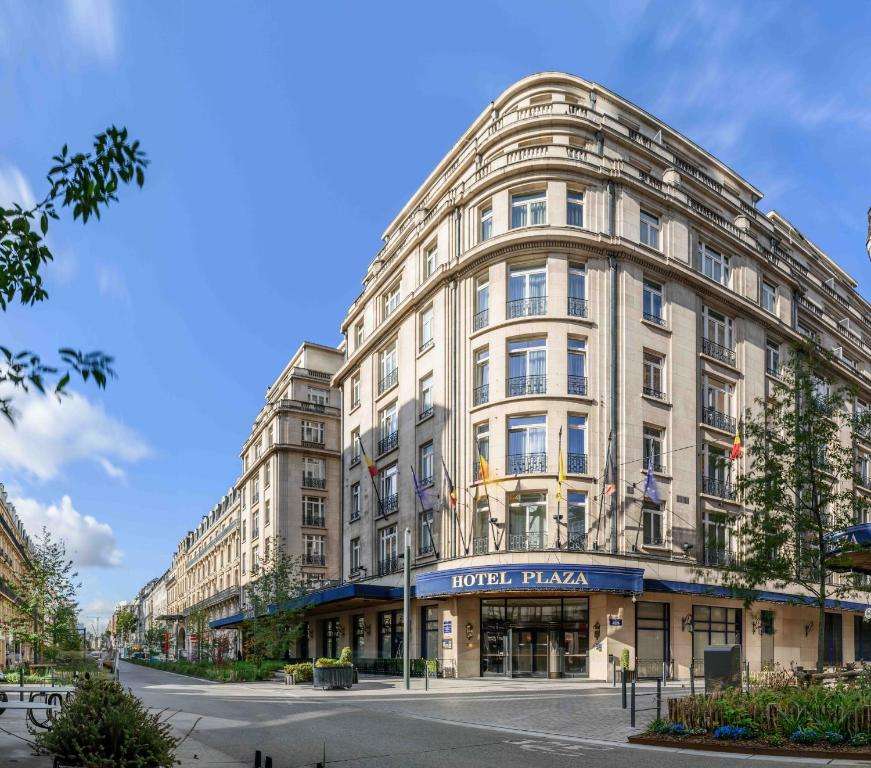 een groot wit gebouw in een stadsstraat bij Hotel Le Plaza Brussels in Brussel
